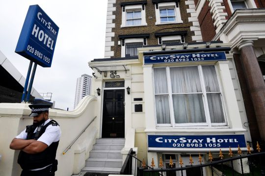 A police officer stands outside the City Stay Hotel